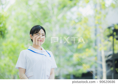 Woman in a white coat outdoors 90620686