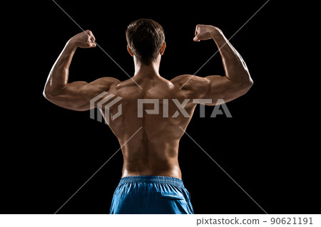 Strong Athletic Man Fitness Model posing back muscles, triceps over black background Strong Athletic Man Fitness Model posing back muscles, triceps over black background 90621191
