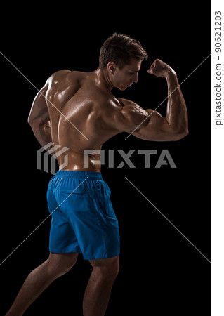 Strong Athletic Man Fitness Model posing back muscles, triceps over black background 90621203