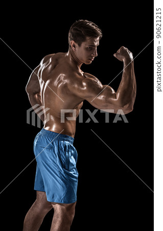 Strong Athletic Man Fitness Model posing back muscles, triceps over black background Strong Athletic Man Fitness Model posing back muscles, triceps over black background 90621215