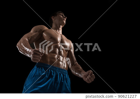 Muscular and fit young bodybuilder fitness male model posing over black background. Muscular and fit young bodybuilder fitness male model posing over black background. 90621227