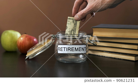 Man Putting Banknote into a Glass with Inscription Retirement, Increasing Savings. Investment and Personal Finance Management Concept Man Putting Banknote into a Glass with Inscription Retirement, Increasing Savings. Investment and Personal Finance Management Concept 90621231