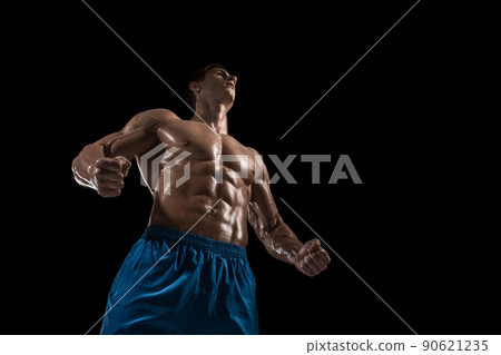 Muscular and fit young bodybuilder fitness male model posing over black background. Muscular and fit young bodybuilder fitness male model posing over black background. 90621235