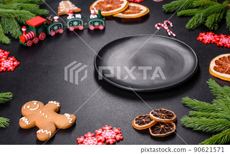 Festive Christmas table with appliances, gingerbreads, tree branches and dried citrus trees Festive Christmas table with appliances, gingerbreads, tree branches and dried citrus trees 90621571