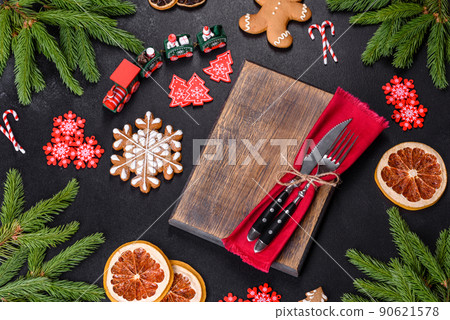 Festive Christmas table with appliances, gingerbreads, tree branches and dried citrus trees Festive Christmas table with appliances, gingerbreads, tree branches and dried citrus trees 90621578