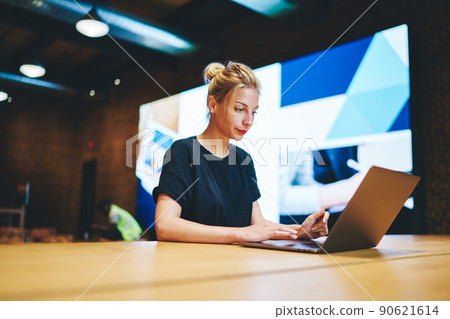 Millennial freelancer searching media content for browsing and download to netbook device 90621614