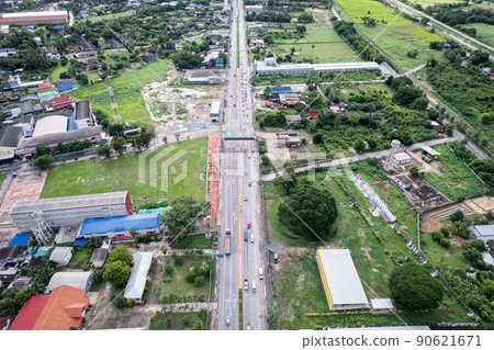 Aerial view of car driving on highway through sub district in suburban area 90621671