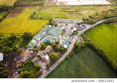 Aerial view of housing estate village with the road through rice field in suburban 90621691
