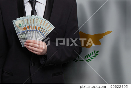 Cypriot business man showing 100 US dollar bills against flag of Republic of Cyprus background 90622595