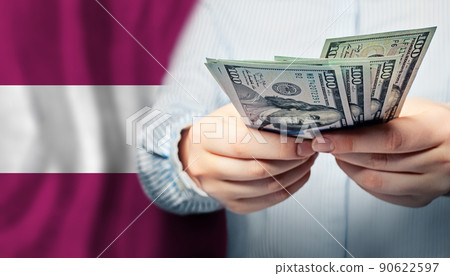 Human hands holds American dollars money on Latvian flag background. Currency exchange Human hands holds American dollars money on Latvian flag background. Currency exchange 90622597