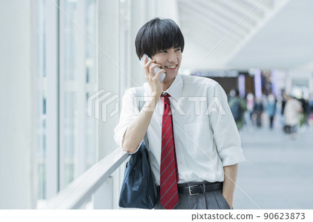 High school boys calling while commuting to school 90623873