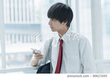 上學路上看手機的高中男生 90623895