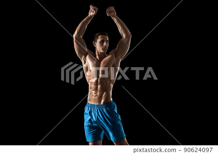 Muscular and fit young bodybuilder fitness male model posing over black background. 90624097