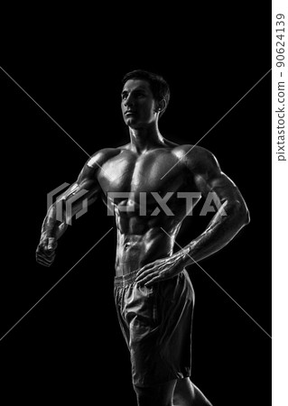 Muscular and fit young bodybuilder fitness male model posing ove 90624139
