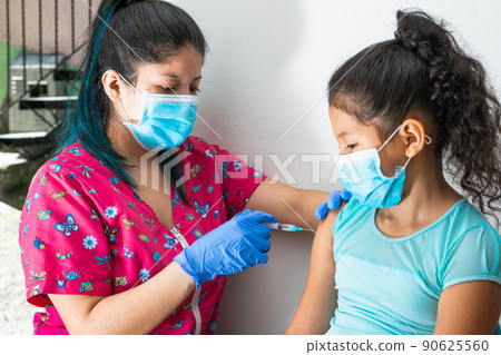 children's nurse injecting brown girl's arm. home-to-home vaccination plan, doctor's hand with rubber gloves injecting covid-19 vaccine. flu vaccine. medical concept, health and pandemic. children's nurse injecting brown girl's arm. home-to-home vaccination plan, doctor's hand with rubber gloves injecting covid-19 vaccine. flu vaccine. medical concept, health and pandemic. 90625560
