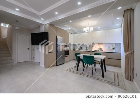 Modern white and beige large luxurious kitchen and dining table in studio apartment 90626101