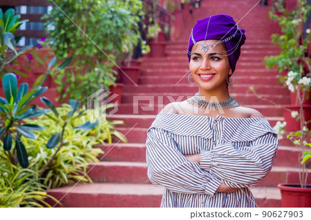 African woman in a dress with a colorful traditional shawl on her head.happy indian female model posing in summer tropical vacation 90627903