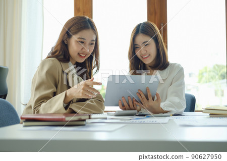Negotiation, Analysis, Discussion, Portrait of an Asian women economist and marketer using tablet computer to plan investments and financial to prevent risks and losses for the company. Negotiation, Analysis, Discussion, Portrait of an Asian women economist and marketer using tablet computer to plan investments and financial to prevent risks and losses for the company. 90627950
