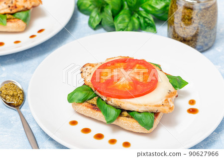 Open face sandwich with chicken, mozzarella, tomato, pesto and basil on toasted ciabatta, horizontal 90627966