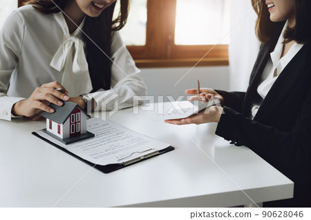 Guarantee, mortgage, contract, contract, signed, real estate agent or bank officer holding a calculator, submits a bid with a customer to buy a home before signing to make a deal. Guarantee, mortgage, contract, contract, signed, real estate agent or bank officer holding a calculator, submits a bid with a customer to buy a home before signing to make a deal. 90628046