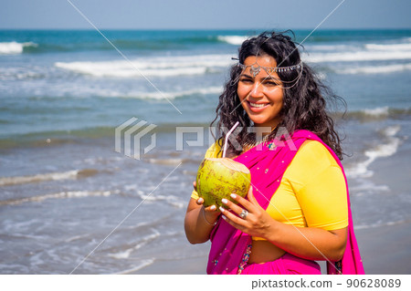 beautiful indian woman in pink stylish sari ,toothy white smile sun summer by sea goa. healthy eating concept Indian Ocean bay beautiful indian woman in pink stylish sari ,toothy white smile sun summer by sea goa. healthy eating concept Indian Ocean bay 90628089