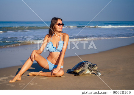 copyspase travel girl posing in a blue bikini swimsuit next to a big male turtle lifestyle vacation paradise untouched deserted beach good morning.tourism guide concept copyspase travel girl posing in a blue bikini swimsuit next to a big male turtle lifestyle vacation paradise untouched deserted beach good morning.tourism guide concept 90628169