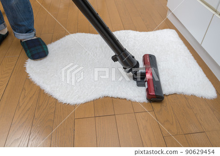 [Middle housewife cleaning rugs with a cyclone cleaner] 90629454