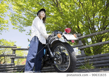 Bike girls image: Young women alongside motorcycles 90631635