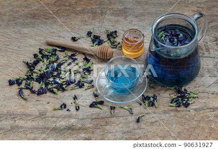 Butterfly pea tea (Clitoria) or Organic blue anchan in Teapot and glass cup served with honey on Old wooden background. 90631927