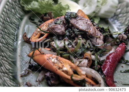 Spicy stir-fried wild boar with herbs and black peppers on green ceramic. 90632473