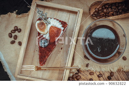 Piece of Red velvet cake serve with Espresso coffee in transparent glass on Wooden cutting board. Piece of Red velvet cake serve with Espresso coffee in transparent glass on Wooden cutting board. 90632822