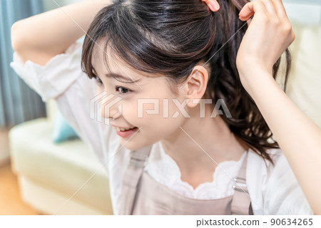 綁她的頭髮的年輕女人 90634265