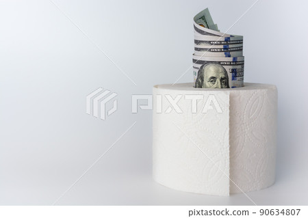 Inflation. The value of money. American 100 dollar bills inserted into toilet paper on a light white gray background. 90634807