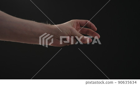 man hand playing with sun light on a black background man hand playing with sun light on a black background 90635634