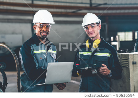 Two factory workers using adept machine equipment in a workshop 90636594