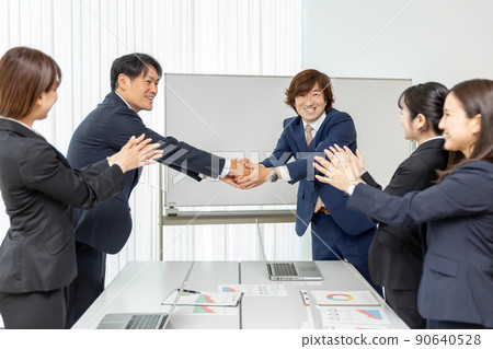 Men and women in suits having business talks in the conference room (contract / handshake) Men and women in suits having business talks in the conference room (contract / handshake) 90640528
