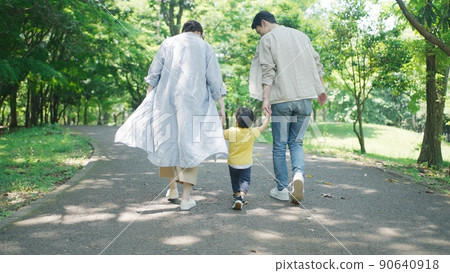 一個家庭手牽著手在公園散步的後視圖 90640918