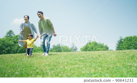 Family playing around on the green hill 90641231