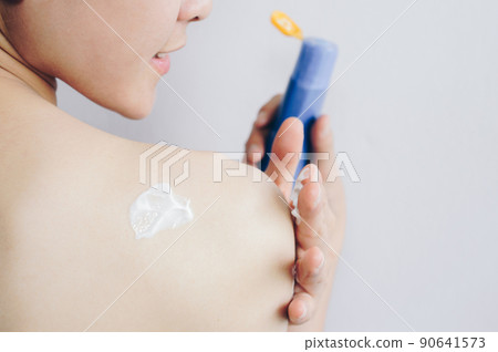 Back view of woman applying sunscreen/sun block lotion on her body for protect her skin from UV sunlight. Back view of woman applying sunscreen/sun block lotion on her body for protect her skin from UV sunlight. 90641573