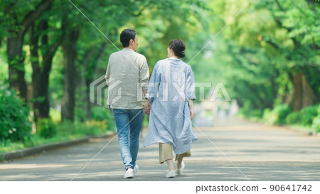 A couple taking a walk in the park in early summer 90641742