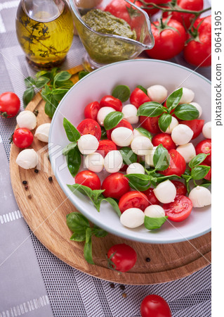 Caprese salad - Mini mozzarella cheese in glass bowl, tomato and basil Caprese salad - Mini mozzarella cheese in glass bowl, tomato and basil 90641905