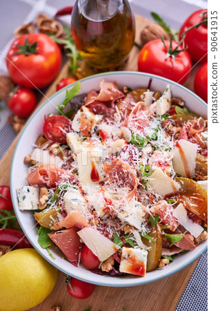 Salad with jamon or prosciutto, pears, tomatoes and arugula on wooden board 90641915