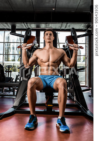Tense muscles of hands under load. Man doing exercise for biceps in the gym. Tense muscles of hands under load. Man doing exercise for biceps in the gym. 90643936