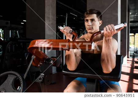 Tense muscles of hands under load. Man doing exercise for biceps in the gym. Tense muscles of hands under load. Man doing exercise for biceps in the gym. 90643951