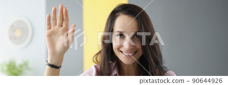Beautiful young woman lift hand as hello gesture sit in living room Beautiful young woman lift hand as hello gesture sit in living room 90644926