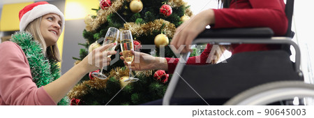 Sisters clink with glasses filled with champagne in cozy home atmosphere Sisters clink with glasses filled with champagne in cozy home atmosphere 90645003