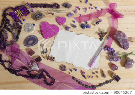 Purple and Pink Jewelry and Flowers with Silver Coin Vintage Paper and Pen in center of Wooden Table Purple and Pink Jewelry and Flowers with Silver Coin Vintage Paper and Pen in center of Wooden Table 90645267