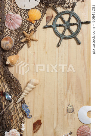 Captains Wheel With Fishing Net and Sea Shells on Wooden Background 90645282