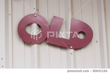 Vintage Metal Sign on Exterior Wall of Small Local Business - Old 90645284