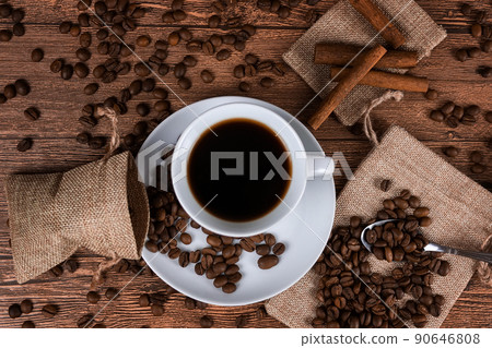 Black coffee foil packaging bag on wooden table top view. Spilled beans flat lay concept. Room for text Black coffee foil packaging bag on wooden table top view. Spilled beans flat lay concept. Room for text 90646808